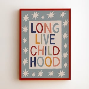 Pode incluir: Uma impressão artística emoldurada com uma borda vermelha. A impressão apresenta as palavras "LONG LIVE CHILDHOOD" em letras coloridas sobre um fundo branco, cercadas por uma borda azul clara com formas de estrelas brancas.