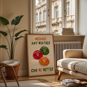 May include: A framed poster with the text "BECAUSE ANY WEATHER CAN BE BETTER" and three Guinness bottle cap designs in red, green, and orange. The poster is in a living room setting with a plant, chair, and sofa.