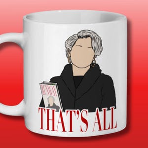 May include: White ceramic mug with a black and white illustration of a woman with gray hair holding a magazine that says "RUNWAY". The text "THAT'S ALL" is printed in red below the illustration.