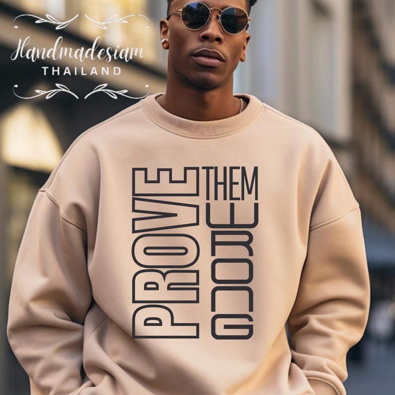 May include: A beige sweatshirt with the words "PROVE THEM WRONG" printed in black on the front.