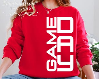 May include: Red sweatshirt with white text that reads "GAMED" in a vertical, stacked format.