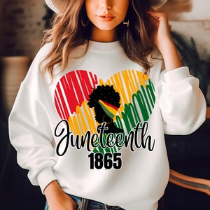 May include: White sweatshirt with a red, yellow and green heart design. The heart features a silhouette of a Black woman with a headband. The text "Juneteenth 1865" is printed below the heart.