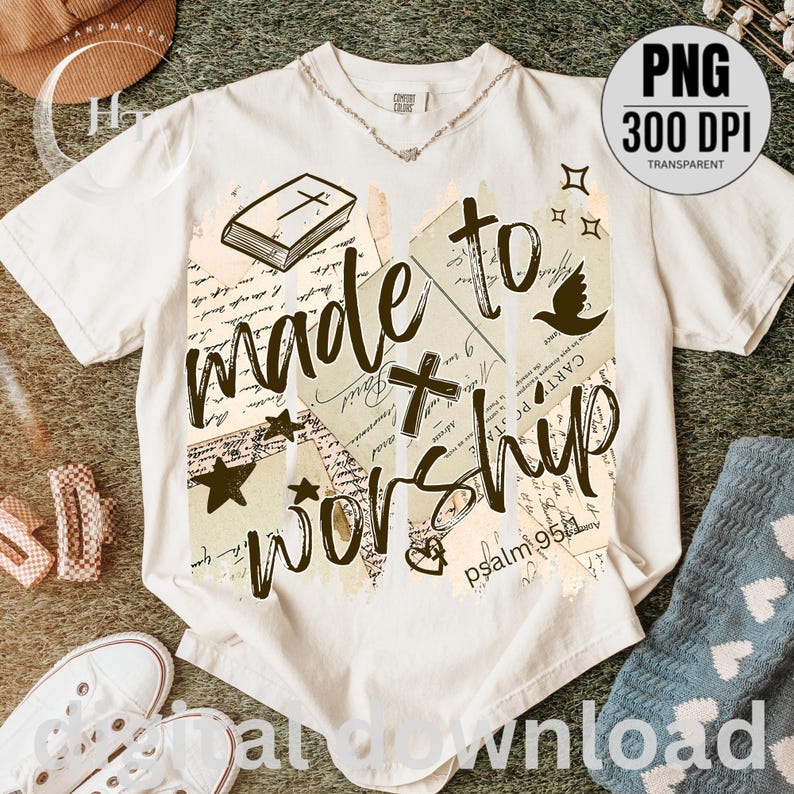 May include: Cream-colored t-shirt with the words "made to worship" in a handwritten style. The design includes a cross, stars, a dove, and a book. The text "psalm 95:1" is also visible.