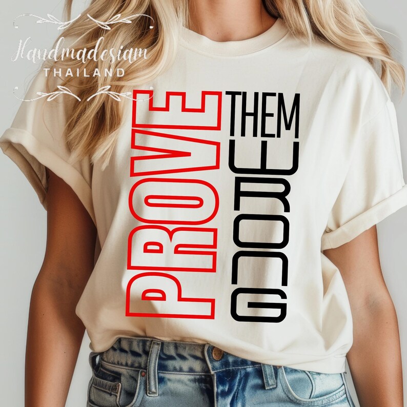 May include: A white t-shirt with the words "PROVE THEM WRONG" printed in red and black. The words are stacked vertically, with "PROVE" in red and "THEM WRONG" in black.