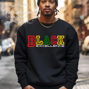 May include: Black sweatshirt with the words "BLACK EXCELLENCE" in red, yellow and green letters.