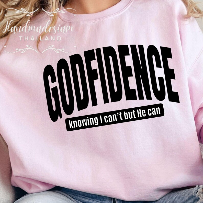 May include: Pink sweatshirt with the text "GODFIDENCE knowing I can't but He can" in black.