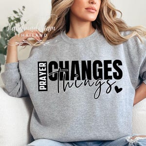 May include: Grey sweatshirt with black text that reads "Prayer Changes Things" with a small heart symbol.