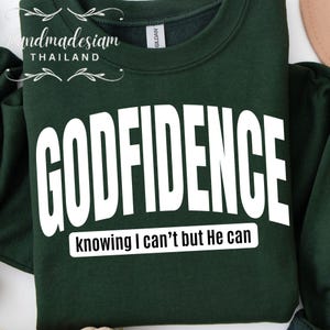 May include: A dark green sweatshirt with the text "GODFIDENCE knowing I can't but He can" in white.