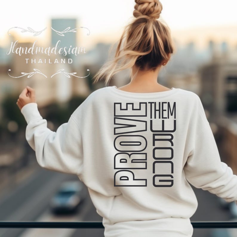 May include: White sweatshirt with the text "PROVE THEM WRONG" printed vertically in black on the back.