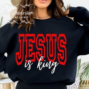 May include: Black sweatshirt with a red graphic that says "JESUS is king" in a bold font.