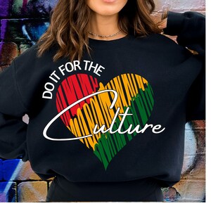 Puede incluir: Sudadera negra con un gráfico en forma de corazón en rojo, amarillo y verde, con el texto "DO IT FOR THE CULTURE" en blanco. El diseño tiene una apariencia texturizada y esbozada.
