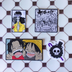 May include: Four embroidered patches featuring anime characters. One rectangular patch shows a skeleton in a yellow shirt, another square patch depicts a character with star-shaped glasses and Japanese text, a wide rectangular patch shows two laughing boys, and a skull patch.