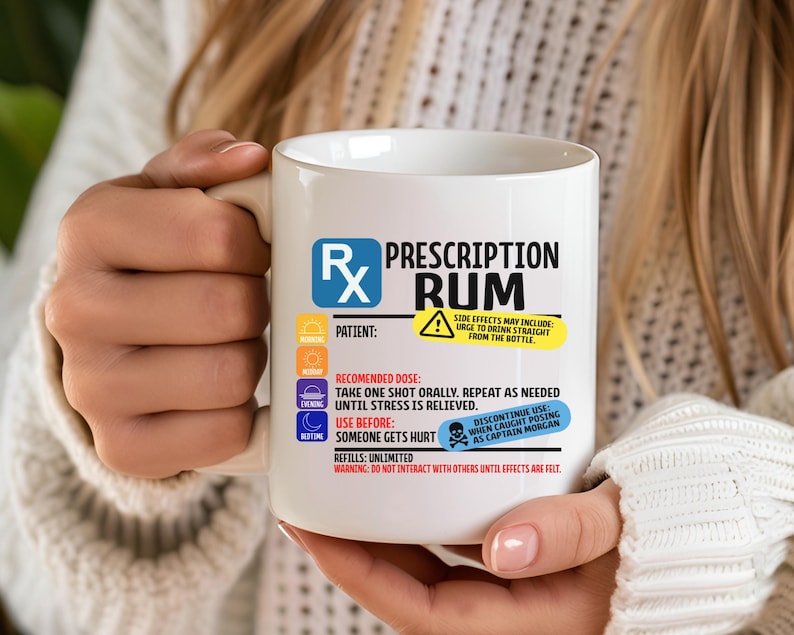Puede incluir: Una taza de cer&aacute;mica blanca con un dise&ntilde;o gr&aacute;fico que imita una etiqueta de receta m&eacute;dica con el texto Prescription Rum. El dise&ntilde;o incluye iconos para ma&ntilde;ana, mediod&iacute;a, tarde y noche, junto con instrucciones y advertencias impresas en texto negro, azul, amarillo y rojo.
