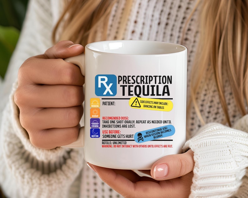 Puede incluir: Una taza de cer&aacute;mica blanca con un gr&aacute;fico de etiqueta de receta que dice Prescription Tequila. El dise&ntilde;o incluye iconos para ma&ntilde;ana, mediod&iacute;a, tarde y noche, junto con texto sobre efectos secundarios, dosis y advertencias en negro, azul y amarillo.