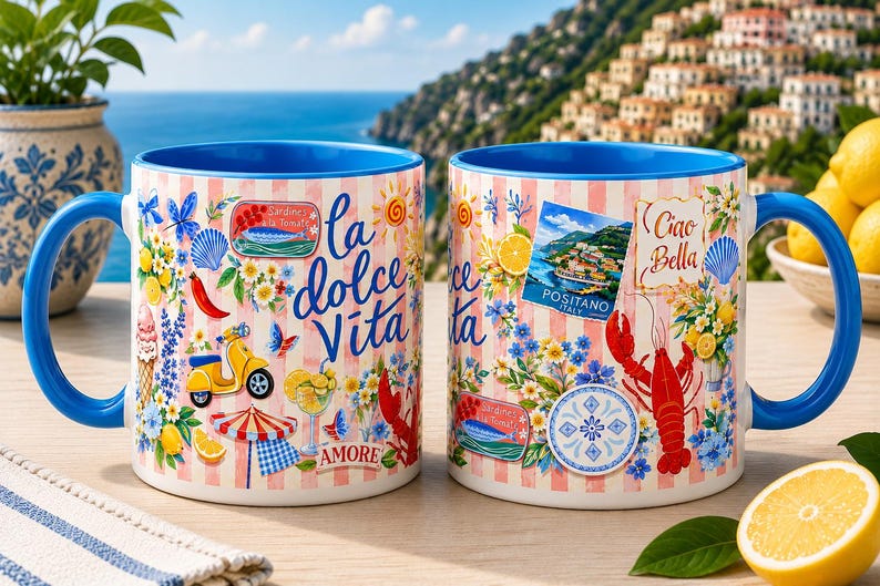 May include: Two ceramic mugs with blue handles and rims, decorated with Italian-themed illustrations. One mug features the text "la dolce Vita" and the other "Ciao Bella". The mugs are adorned with images of lemons, a scooter, and a lobster.