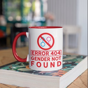 Könnte beinhalten: Weißer Keramikbecher mit rotem Innenraum und Henkel. Der Becher zeigt eine rote Grafik mit dem Text "ERROR 404 GENDER NOT FOUND" und einem durchgestrichenen Geschlechtssymbol.