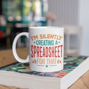May include: White ceramic coffee mug with a colorful graphic that reads "I'm silently creating a spreadsheet for that".