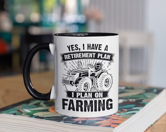 Könnte beinhalten: Eine weiße Keramiktasse mit schwarzem Henkel und schwarzem Rand. Die Tasse zeigt ein Schwarzweißbild eines Traktors mit dem Text "Ja, ich habe einen Ruhestandsplan. Ich plane, Landwirtschaft zu betreiben."