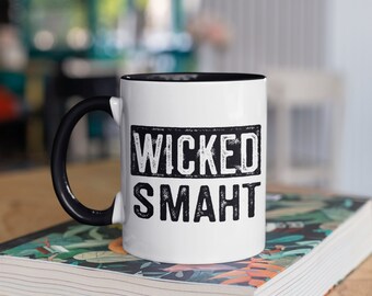 May include: White ceramic mug with a black rim and handle. The mug has black text that reads "WICKED SMAHT" in a distressed font.