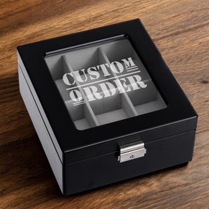 May include: Black wooden box with a glass top and a silver latch. The box has six compartments and the text "CUSTOM ORDER" is printed on the glass.