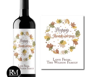 Könnte beinhalten: Ein Weinetikett mit Thanksgiving-Motiv. Das Etikett zeigt einen Kranz aus Herbstblättern in Braun-, Gelb- und Grüntönen. Der Text "Happy Thanksgiving!" ist in einer kursiven Schrift geschrieben. Das Etikett enthält auch den Text "Love From, The Wilson Family".