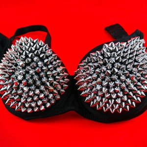 May include: A black bra with silver pyramid-shaped studs covering the cups.
