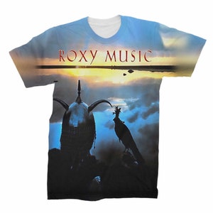 Könnte beinhalten: Ein weißes T-Shirt mit einem vollfarbigen Druck eines Sonnenuntergangs über einem Gewässer. Der Text "ROXY MUSIC" ist oben auf dem Bild in Rot gedruckt. Eine silhouettierte Figur mit Helm und ein Vogel befinden sich im Vordergrund.