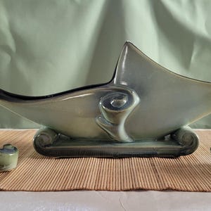 May include: A set of three vintage ceramic pieces in a green and brown glaze. The centre piece is a large bowl with a unique shape, and the two smaller pieces are shaped like stylised pinecones.