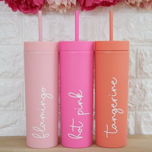 May include: Three tall, clear plastic tumblers with lids and straws. The tumblers are pink, hot pink, and orange. The tumblers are labeled "flamingo", "hot pink", and "tangerine".
