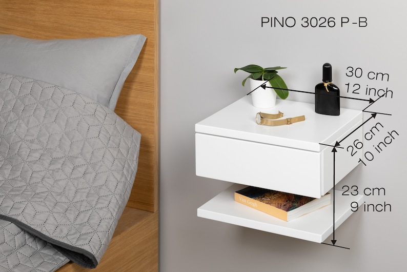 May include: White floating nightstand with a drawer and a shelf. The nightstand is 12 inches wide, 10 inches deep, and 9 inches tall. It is labeled "PINO 3026 P-B".