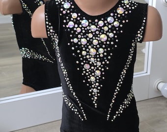 Peut inclure: Justaucorps noir orné de strass irisés. Le justaucorps sans manches présente un col en V et est orné d'un motif de strass sur le devant et le dos. Le justaucorps est présenté sur un mannequin.