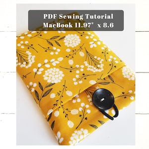 May include: A yellow fabric laptop sleeve with a white floral pattern and a black button closure. The sleeve is designed for a MacBook 11.97" x 8.6". PDF Sewing Tutorial.