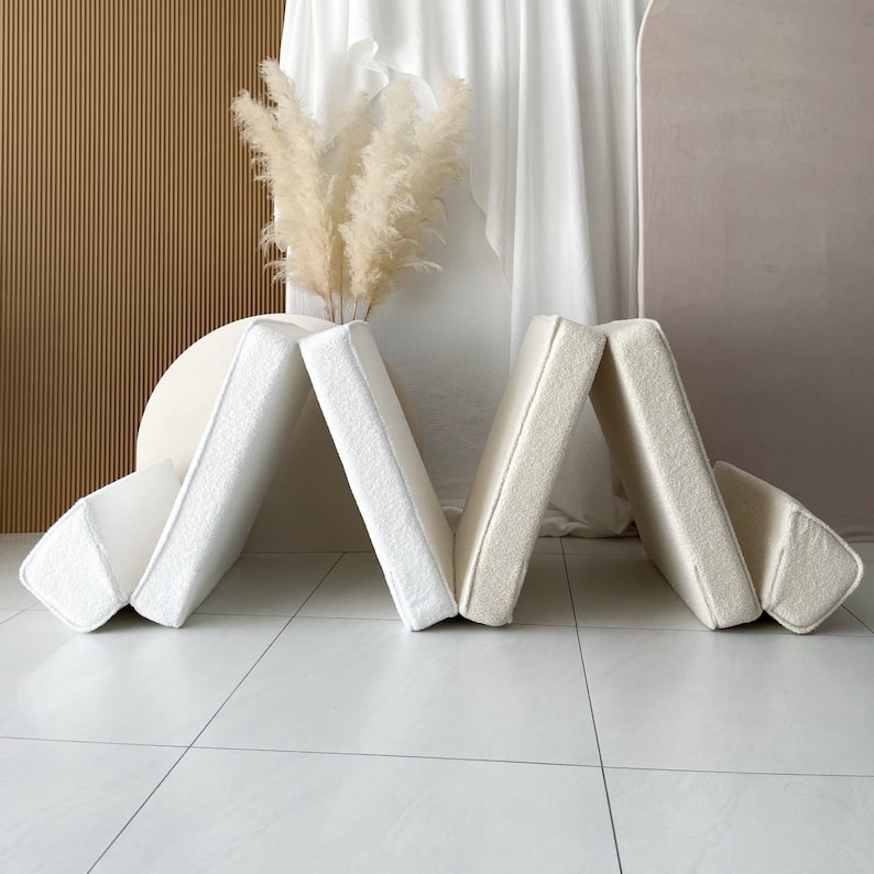 May include: A set of six off-white foam cushions arranged in a curved shape. The cushions are soft and plush, and they would be perfect for a playroom or nursery.