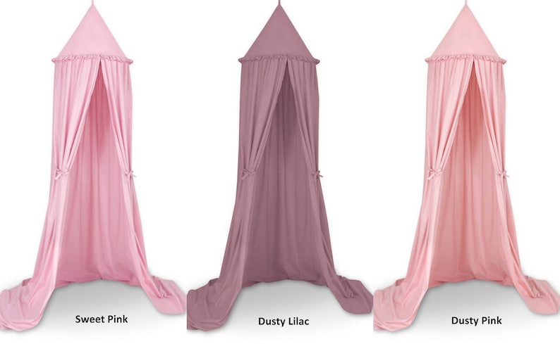 Puede incluir: Tres cortinas de cama con dosel en diferentes colores: rosa dulce, lila polvoriento y rosa polvoriento. Cada cortina tiene un borde con volantes y lazos en la parte inferior.