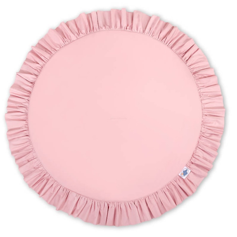 Puede incluir: Una alfombra de juego redonda de color rosa con un borde con volantes. La alfombra est&aacute; hecha de un tejido suave y c&oacute;modo, ideal para beb&eacute;s y ni&ntilde;os peque&ntilde;os.
