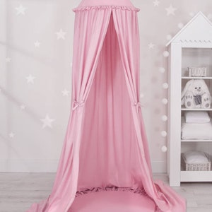 Puede incluir: Una tienda de campa&ntilde;a rosa con un borde con volantes y una alfombra redonda rosa a juego. La tienda est&aacute; hecha de un tejido suave y ligero, ideal para crear un espacio acogedor y privado para los ni&ntilde;os.