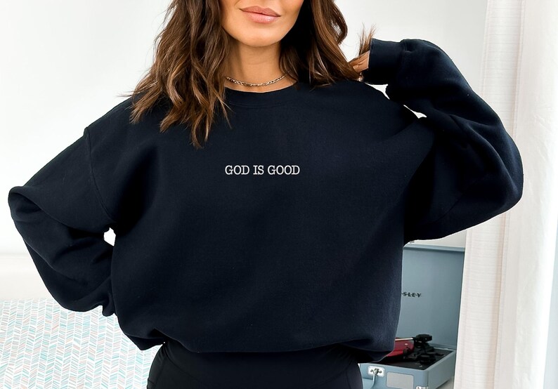 May include: Black sweatshirt with the text "GOD IS GOOD" in white lettering.
