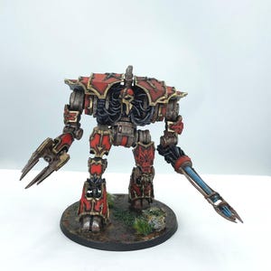 May include: A detailed miniature robot figure, primarily red and metallic, with intricate armor and weaponry. The figure stands on a circular base with simulated terrain. The robot has a menacing appearance, with sharp edges and a mechanical design.