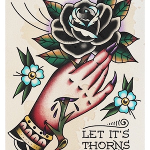 Op de afbeelding: Een traditionele tattoo-stijl illustratie van een hand die een zwarte roos met doornen vasthoudt. De hand is doorboord door de rozenstengel en er druppelt bloed. De tekst "LET IT'S THORNS CUT YOU" staat onder de afbeelding.
