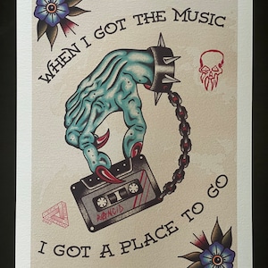 Puede incluir: Una ilustración de tatuaje de estilo vintage que presenta una mano azul con garras afiladas sosteniendo una cinta de casete. El texto "WHEN I GOT THE MUSIC I GOT A PLACE TO GO" está escrito en letras negras. La imagen también incluye una calavera, un triángulo y dos flores azules.