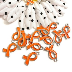 May include: A group of 12 orange ribbon charms with silver metal accents. The charms are in the shape of a ribbon with a loop at the top for attaching to a necklace, bracelet, or other jewelry.