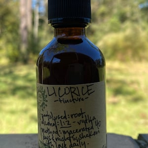 May include: A brown glass bottle with a dropper top and a label that reads "LICORICE -tincture- partis) used: root alcohol:1:2 -vodka Method: macerated 40 days & nights, shaken with love daily."