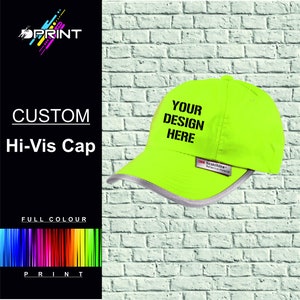 Op de afbeelding: Een felgele hi-vis cap met een reflecterende band rond de rand. De cap heeft een zwart geborduurd ontwerp met de tekst "YOUR DESIGN HERE".