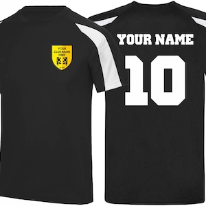 May include: Black athletic jersey with white shoulder stripes. The front features a yellow crest with text "YOUR CLUB NAME HERE". The back displays "YOUR NAME" and the number "10" in white.