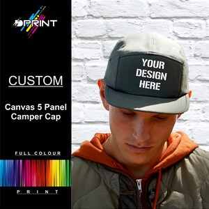 May include: A green canvas 5-panel camper cap with white text that reads "YOUR DESIGN HERE".