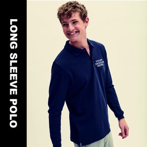 Puede incluir: Una camisa polo de manga larga azul marino con una tapeta de botones blanca y un diseño bordado blanco que dice "YOUR DESIGN HERE".