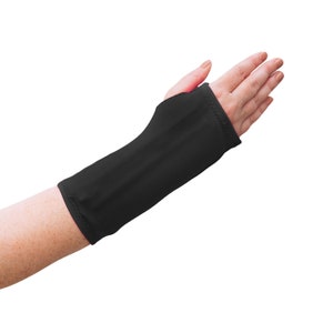 May include: Black wrist support brace made of soft, stretchy fabric. The brace is designed to provide support and stability to the wrist.