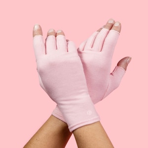 May include: A pair of pink fingerless gloves with a small logo on the wrist.