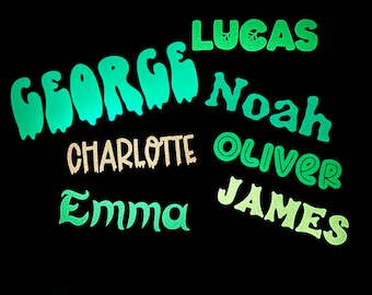 May include: A black background with green and white text spelling out the names George, Lucas, Noah, Oliver, Charlotte, Emma, and James.