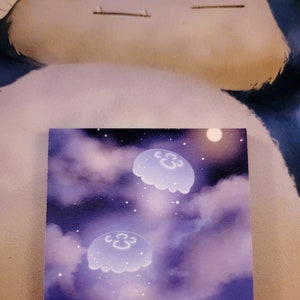 May include: A purple and white painting of three glowing jellyfish floating in a starry night sky. The painting is signed "soul.e.art" in the bottom left corner.